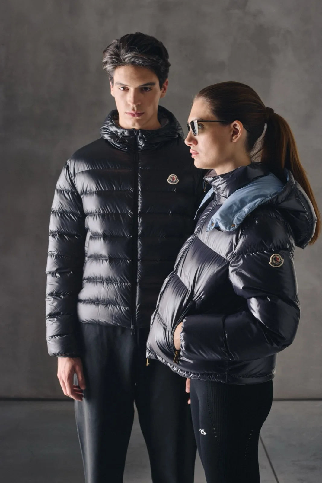 Un uomo e una donna con piumini Moncler lucidi